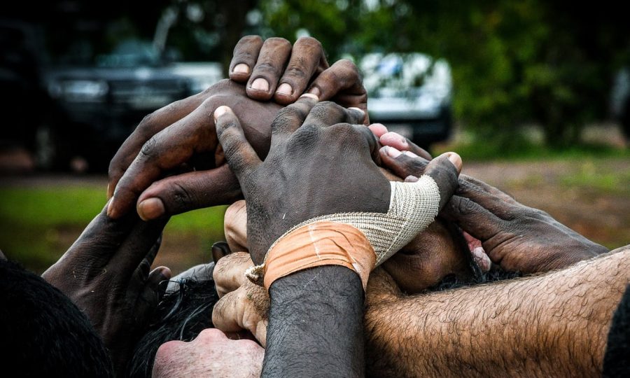 The+Tiwi+Bombers+players+join+hands+during+their+clash+with+the+Crocs%3A+Photo+Jack+Banister