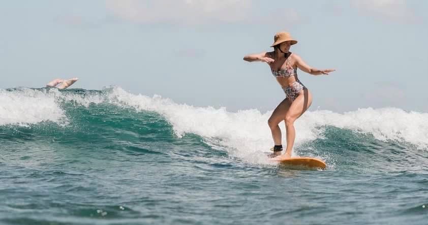 A girl riding a wave on a surfboard in the water