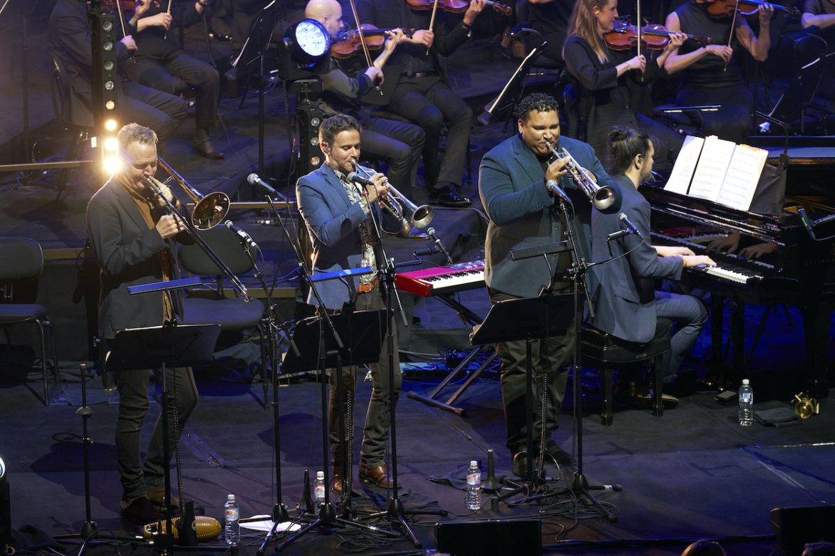 A group of people playing instruments and performing on a stage