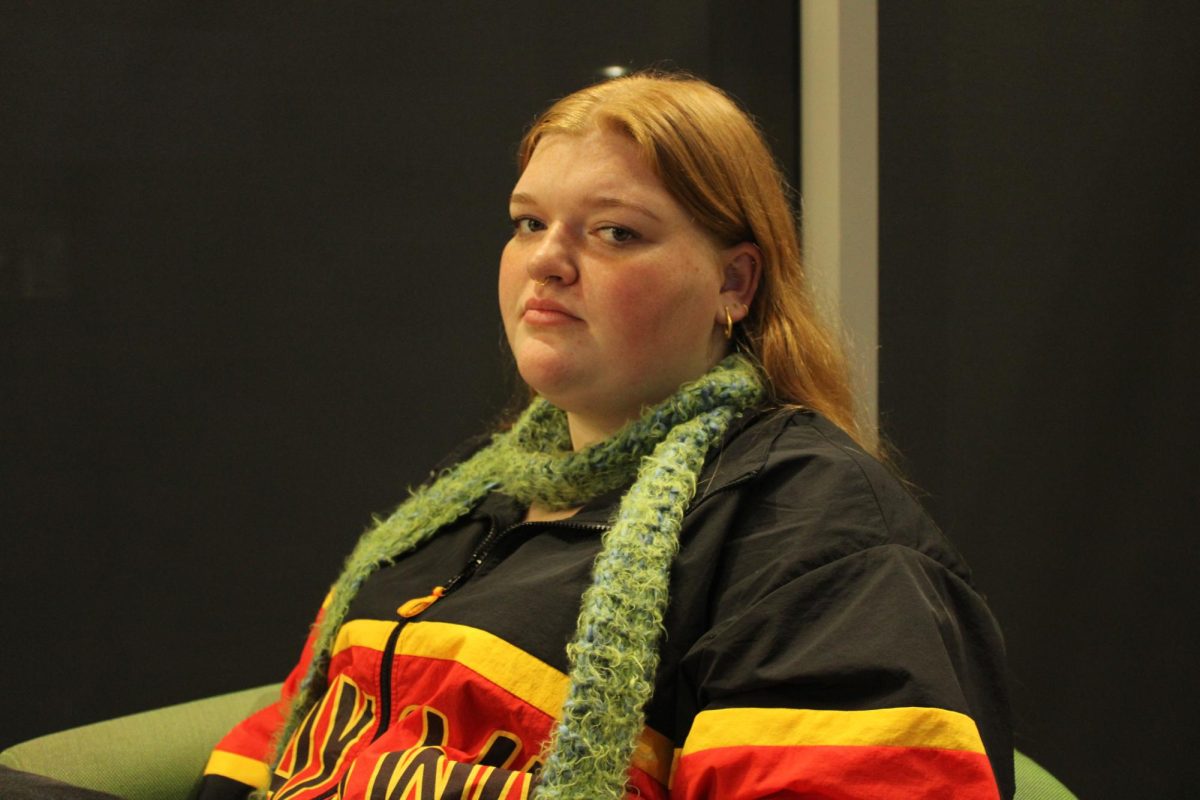 A woman wearing a colorful shirt and smiling at the camera