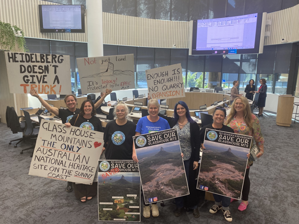 A group of people standing next to a sign